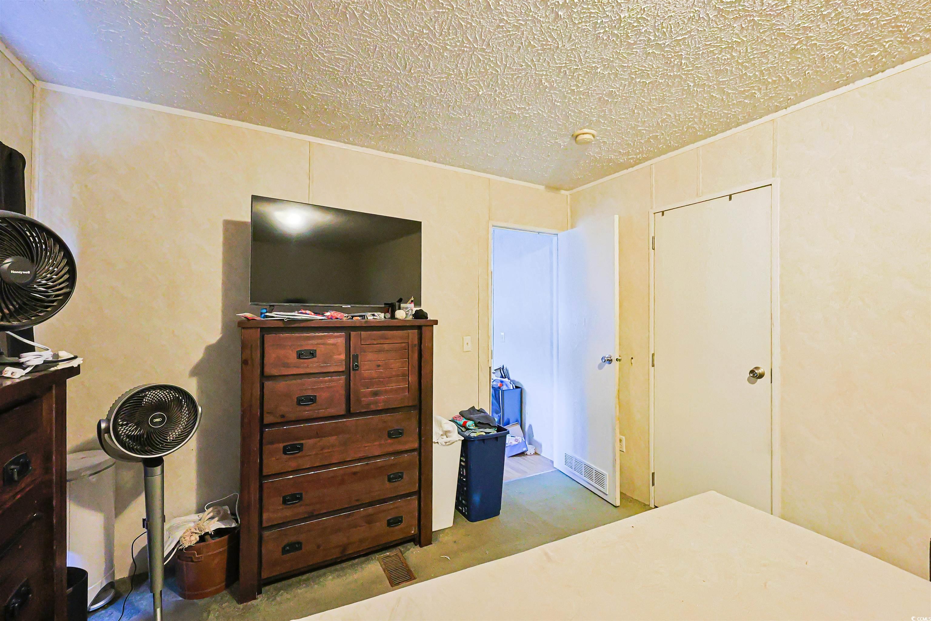 2128 Harvey Road Loris, SC 29569 - Photo 17 of 31 Bedroom featuring a textured ceiling and light colored carpet