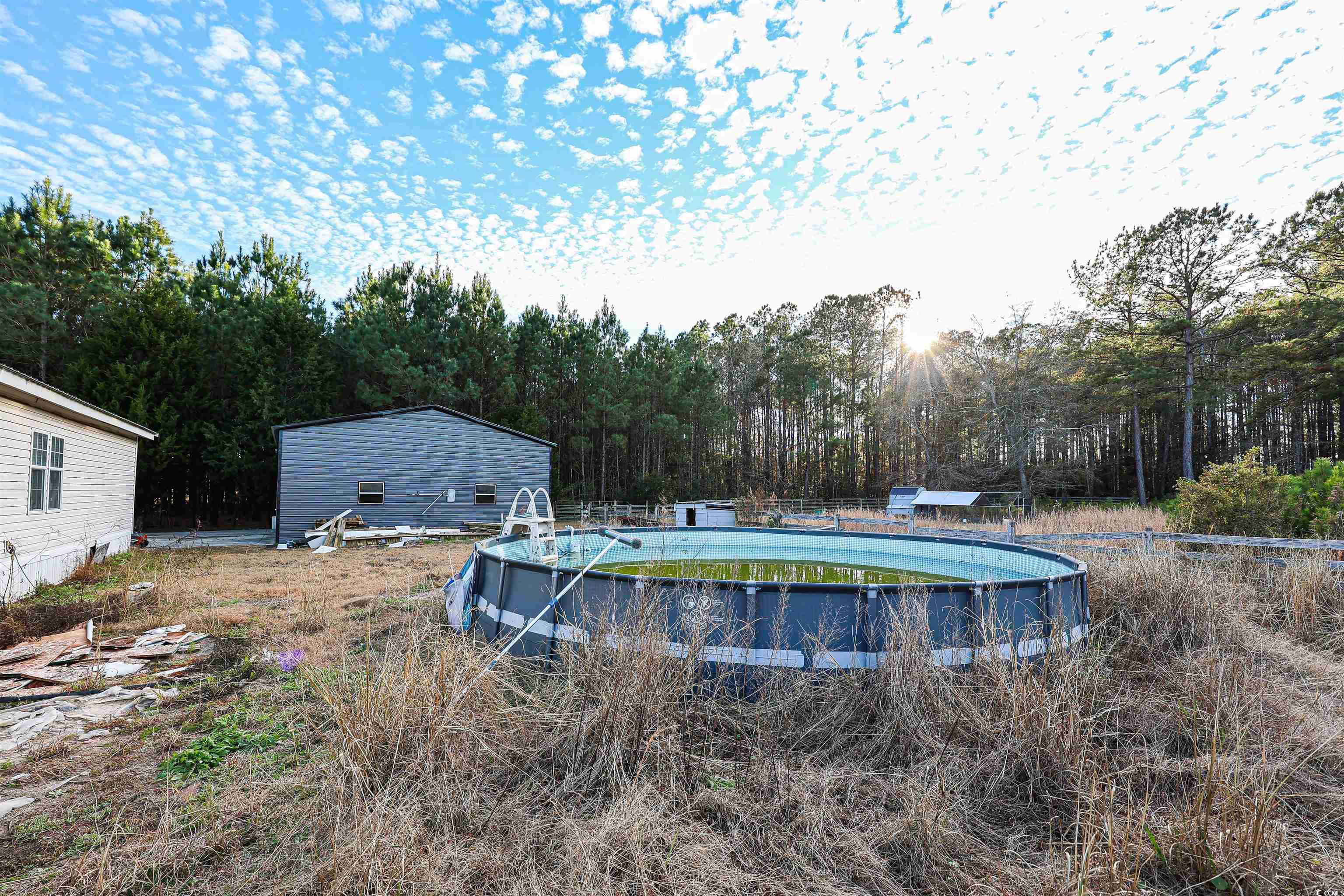 2128 Harvey Road Loris, SC 29569 - Photo 23 of 31 View of swimming pool with a patio, an empty pool, and a wooded view