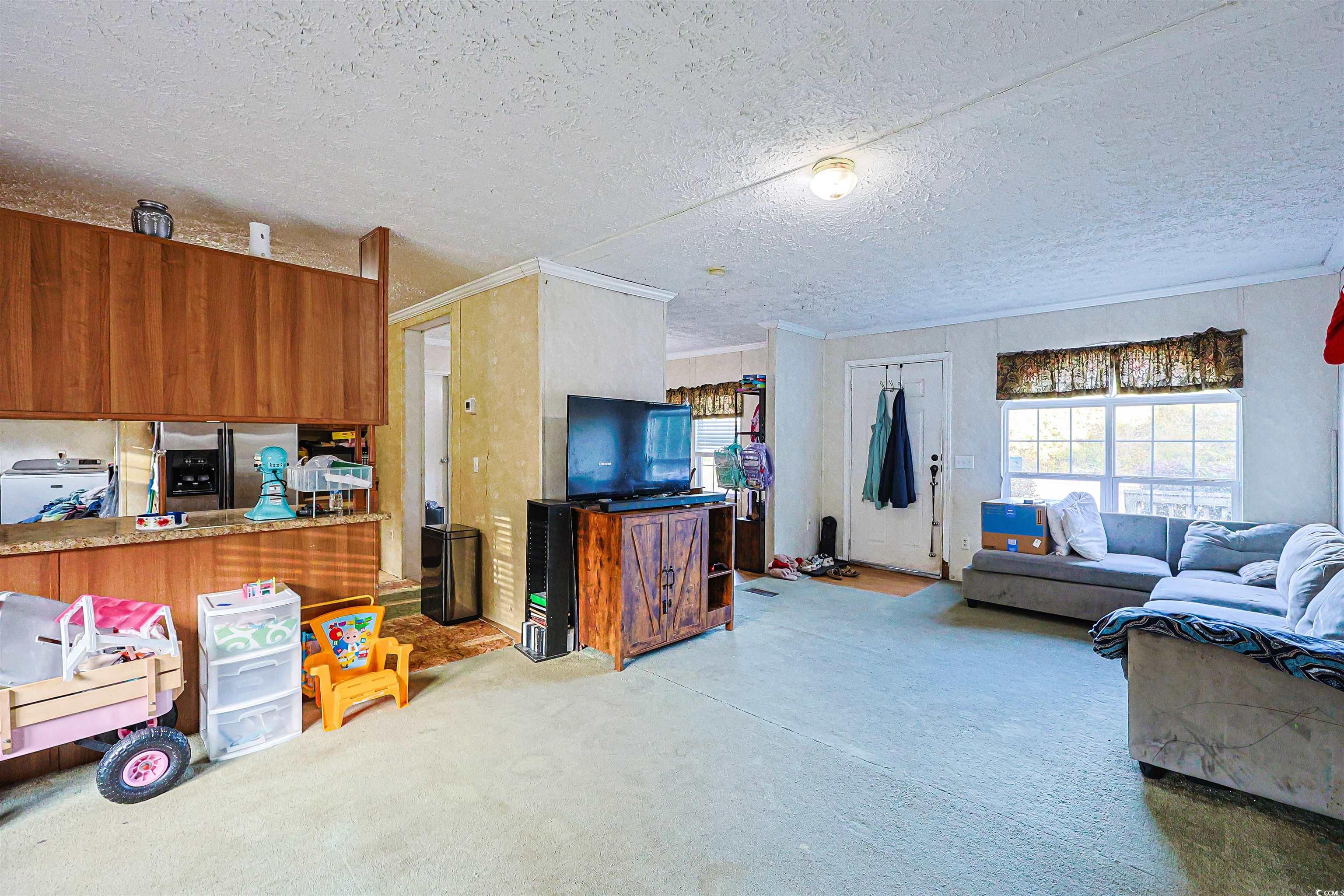 2128 Harvey Road Loris, SC 29569 - Photo 3 of 31 Living area with healthy amount of natural light, crown molding, and a textured ceiling