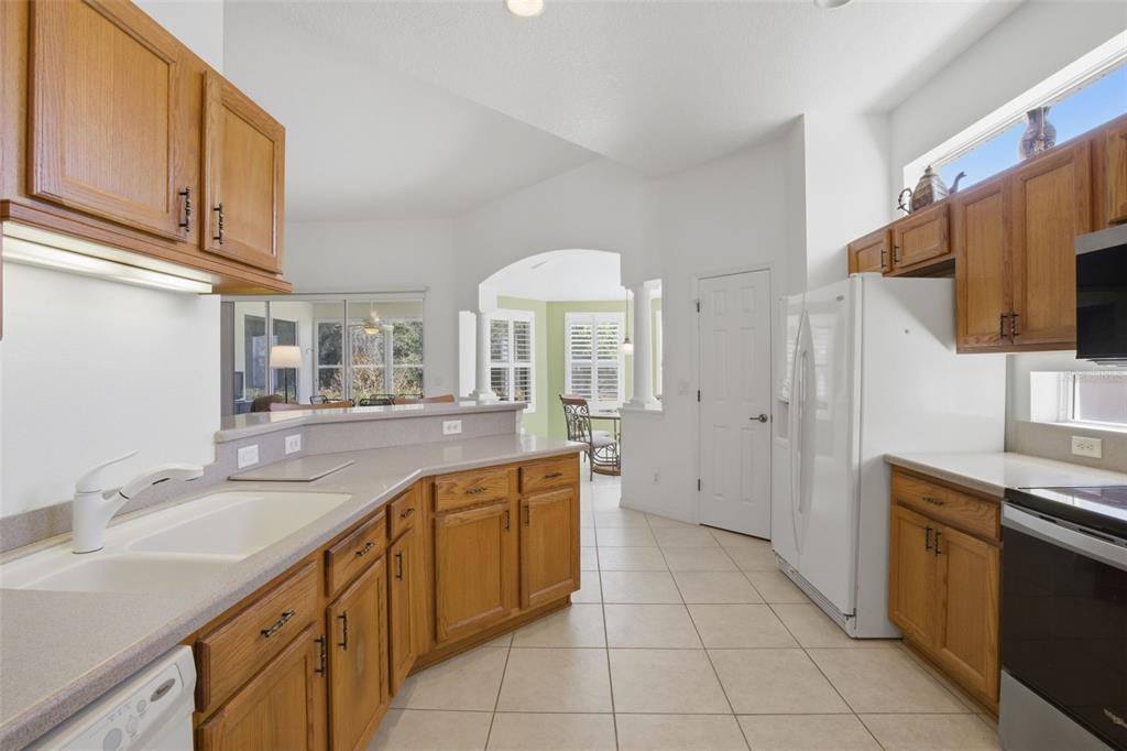 5922 Sage Leaf Place Leesburg, FL 34748 - Photo 14 of 39 a kitchen with a sink stove and cabinets