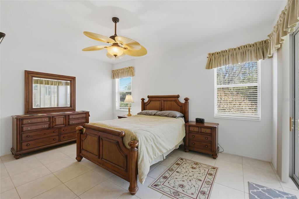 5922 Sage Leaf Place Leesburg, FL 34748 - Photo 15 of 39 a bedroom with a bed and a chandelier