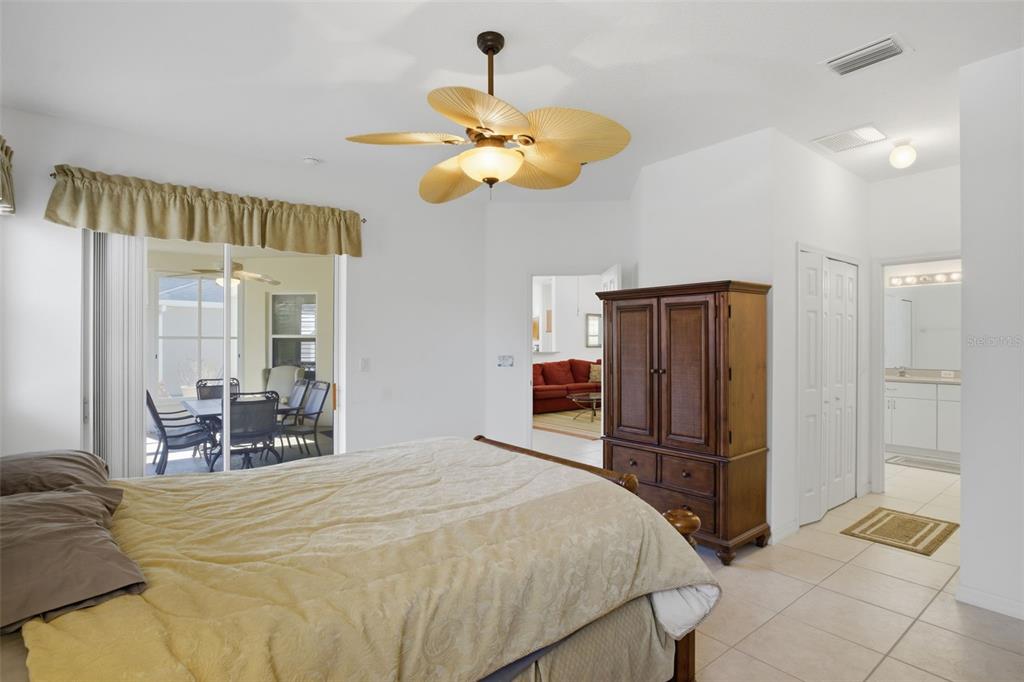 5922 Sage Leaf Place Leesburg, FL 34748 - Photo 16 of 39 a bedroom with a bed and chandelier
