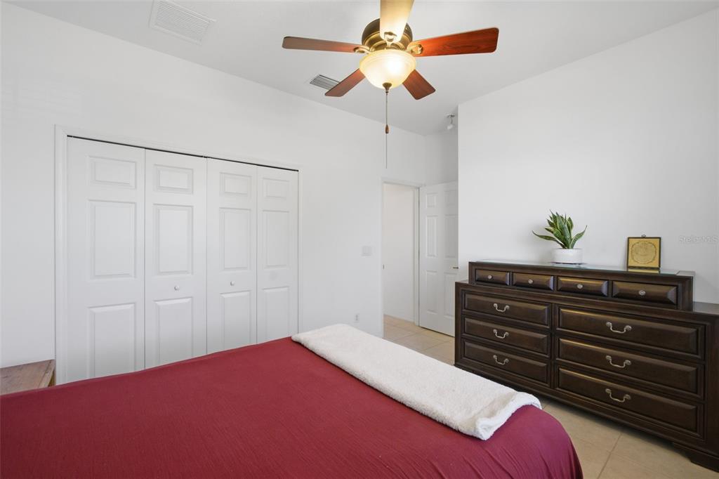 5922 Sage Leaf Place Leesburg, FL 34748 - Photo 20 of 39 a bedroom with a bed and a chandelier