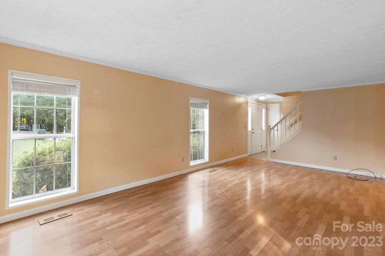 112 Walnut Street Lowell, NC 28098 - Photo 19 of 27 a view of an empty room with wooden floor and a window
