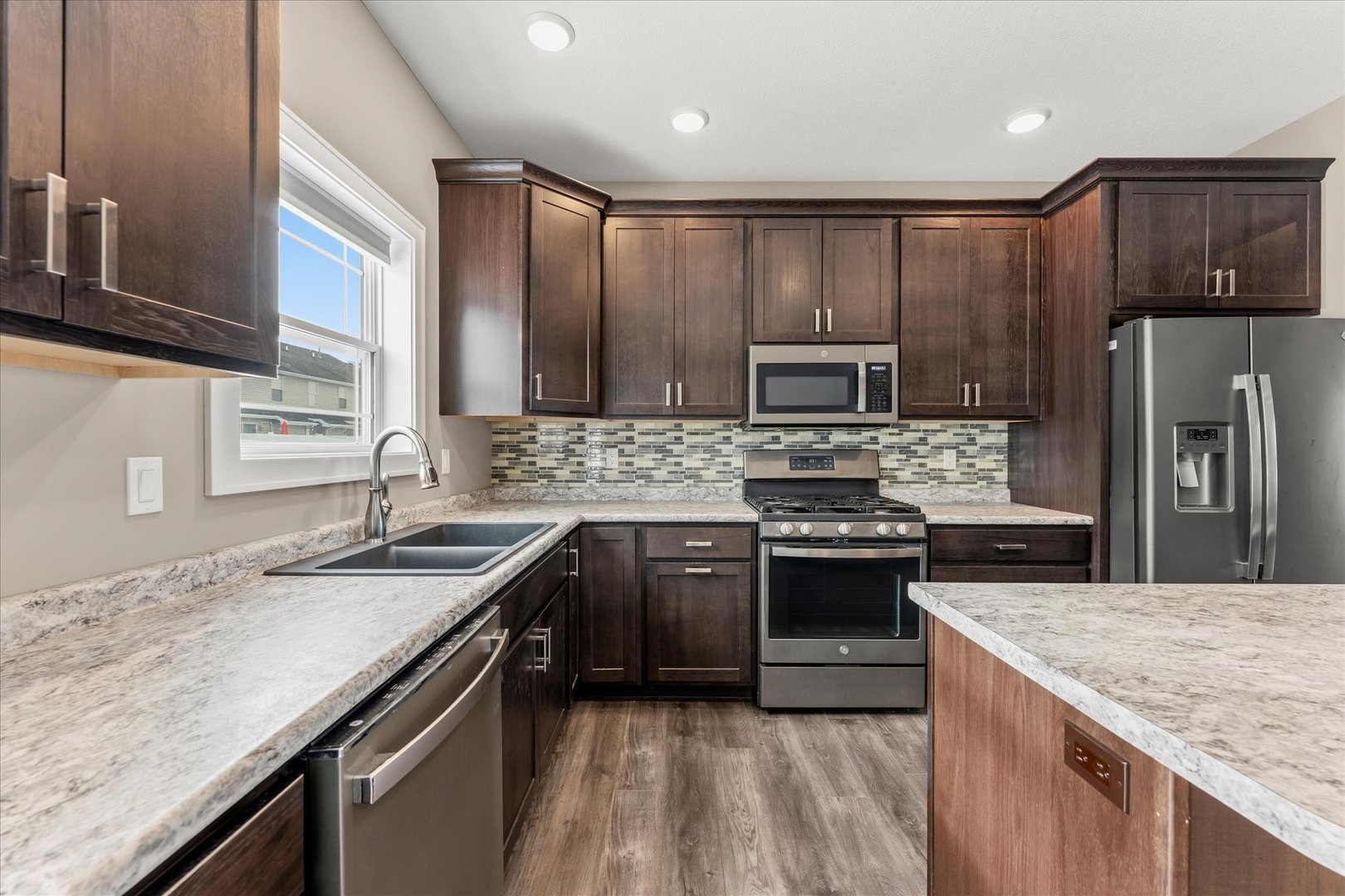 3411 Boulder Ridge Drive Champaign, IL 61822 - Photo 12 of 36 a kitchen with stainless steel appliances granite countertop a sink stove microwave and refrigerator