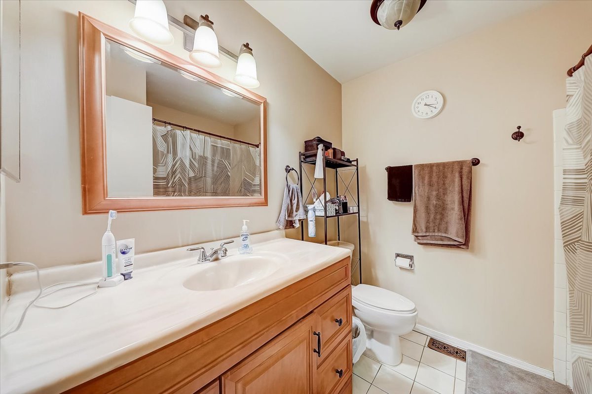 1110 Scanlon Drive, Unit D1 Wheeling, IL 60090 - Photo 14 of 23 a bathroom with a sink toilet and mirror