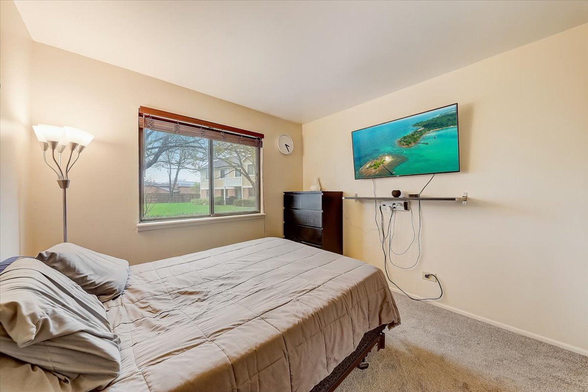 1110 Scanlon Drive, Unit D1 Wheeling, IL 60090 - Photo 21 of 23 a bedroom with a bed and a flat screen tv