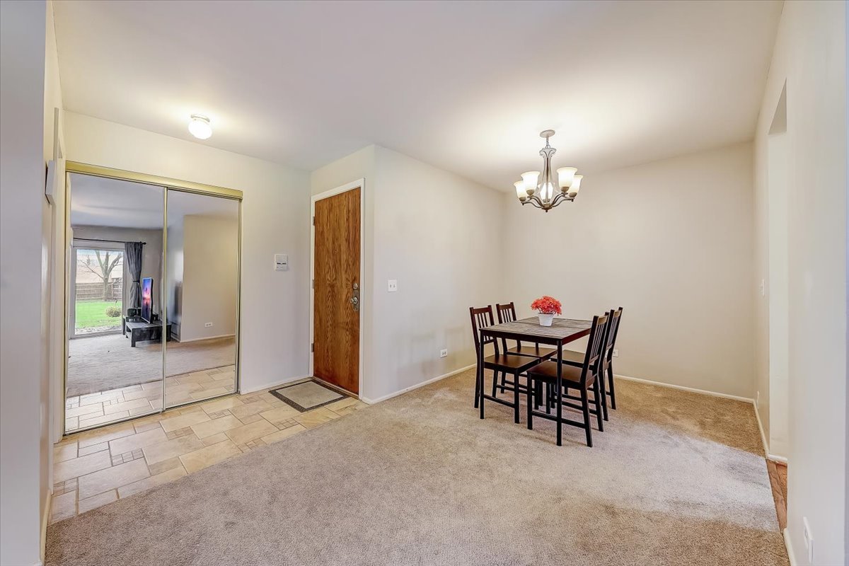 1110 Scanlon Drive, Unit D1 Wheeling, IL 60090 - Photo 6 of 23 a dining room with furniture and chandelier
