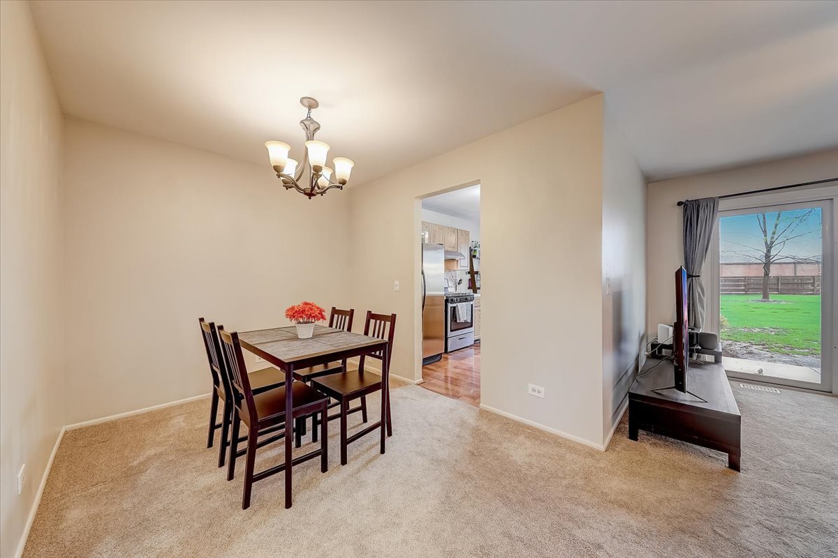 1110 Scanlon Drive, Unit D1 Wheeling, IL 60090 - Photo 7 of 23 a dining room with furniture and chandelier