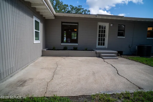 a view of a yard in front of a house with large trees