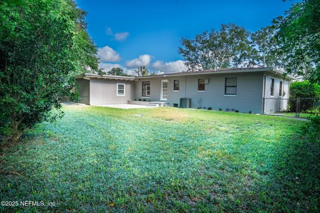 a backyard of a house with table and chairs