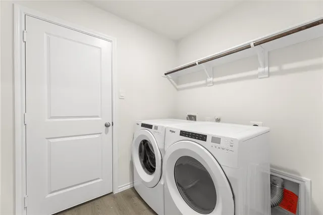 a view of a hallway with wooden floor and a bathroom