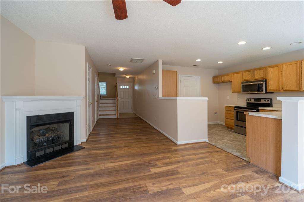 a view of kitchen with granite countertop stove top oven and refrigerator