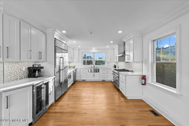 a large kitchen with stainless steel appliances kitchen island a large counter top and a wooden floors