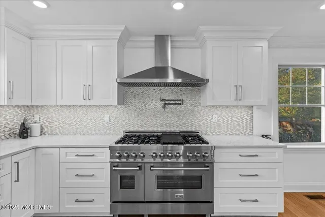 a kitchen with granite countertop white cabinets and white stove