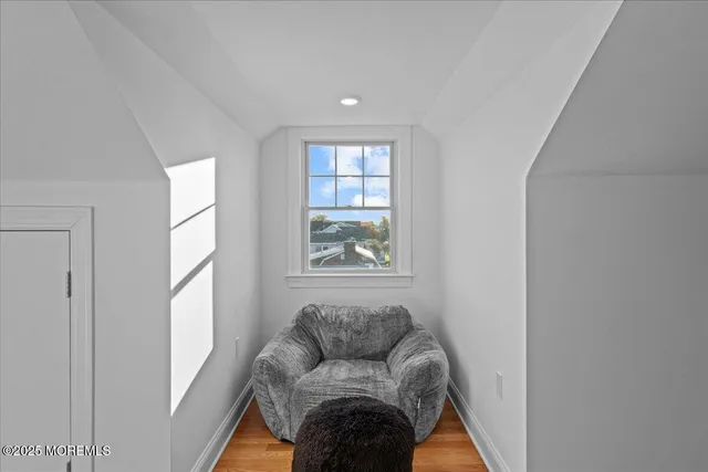 a view of a livingroom with wooden floor and a refrigerator