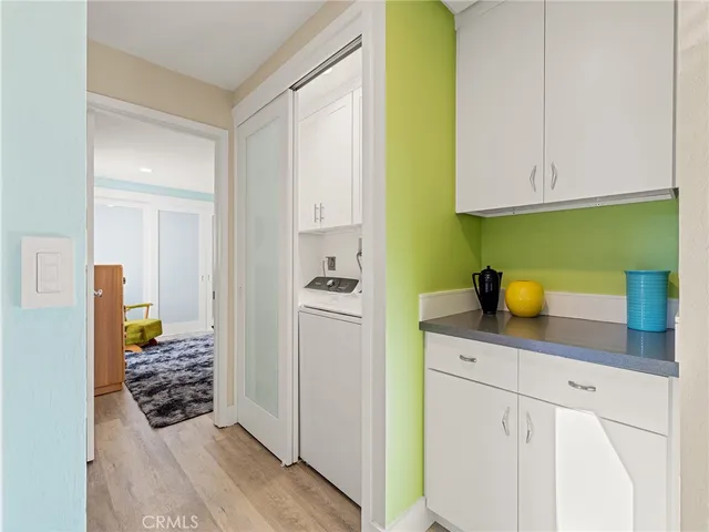 a view of a hallway with wooden floor and a bathroom