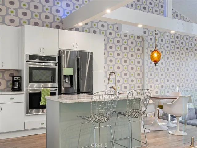 a kitchen with stainless steel appliances kitchen island granite countertop a stove and a sink