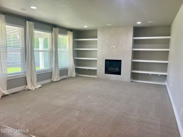 a view of an empty room with a fireplace and a window
