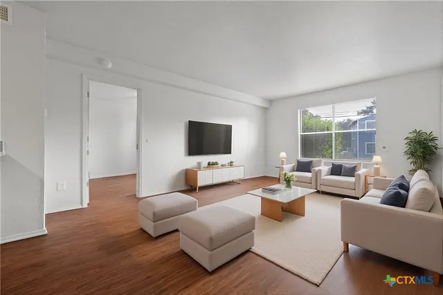 a living room with furniture wooden floor and a flat screen tv
