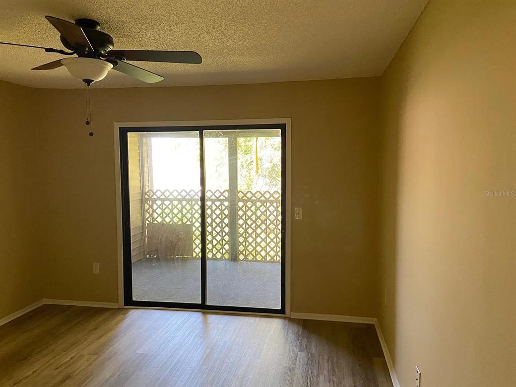 12065 Proctor Loop, Unit 7 New Port Richey, FL 34654 - Photo 6 of 6 a view of an empty room with wooden floor and a window