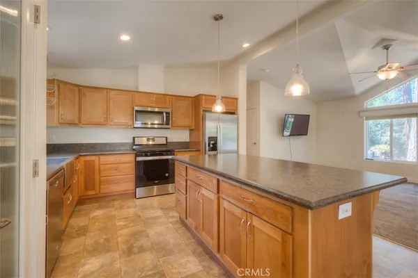 a kitchen with stainless steel appliances granite countertop a stove a sink and a refrigerator