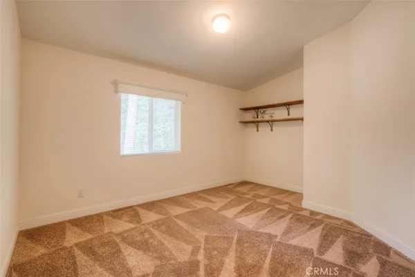 a view of a big room with wooden floor and windows in it