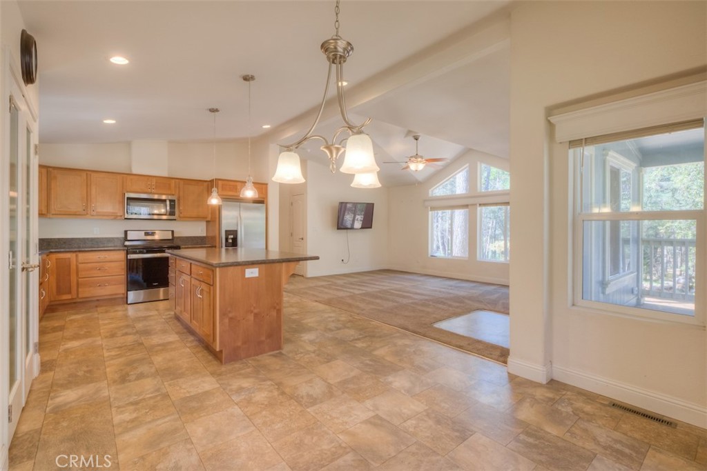 14565 Coutolenc Road Magalia, CA 95954 - Photo 3 of 43 a kitchen with stainless steel appliances granite countertop a refrigerator a oven a sink a island and couches with wooden floor