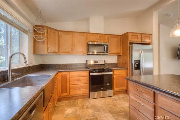 a kitchen with stainless steel appliances granite countertop a sink stove and refrigerator