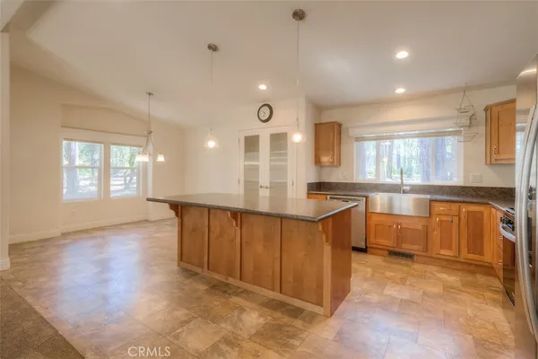 a large kitchen with kitchen island white cabinets and wooden floor