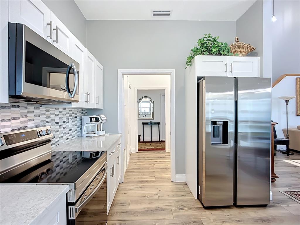2424 69th Avenue West, Unit 2424 Bradenton, FL 34207 - Photo 15 of 49 a kitchen with stainless steel appliances kitchen island granite countertop a refrigerator and a stove top oven
