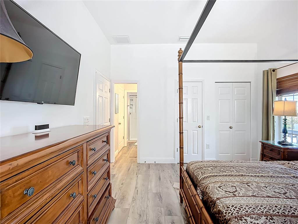 2424 69th Avenue West, Unit 2424 Bradenton, FL 34207 - Photo 25 of 49 a bedroom with a bed and a flat tv screen on a dresser