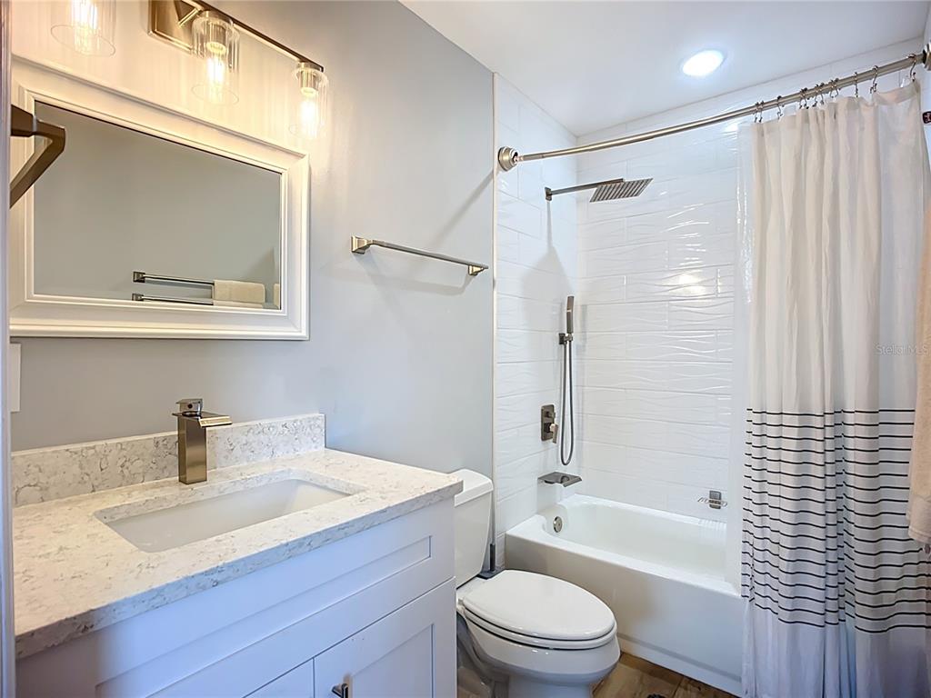 2424 69th Avenue West, Unit 2424 Bradenton, FL 34207 - Photo 32 of 49 a bathroom with a sink toilet a shower and a mirror