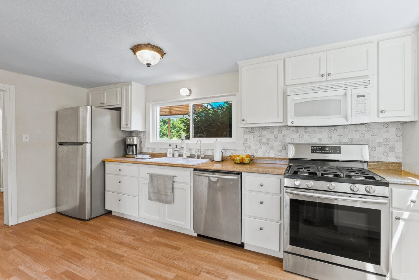 129 Browns Valley Road, Unit A Watsonville, CA 95076 - Photo 9 of 45 a kitchen with stainless steel appliances white cabinets a stove a sink and a refrigerator