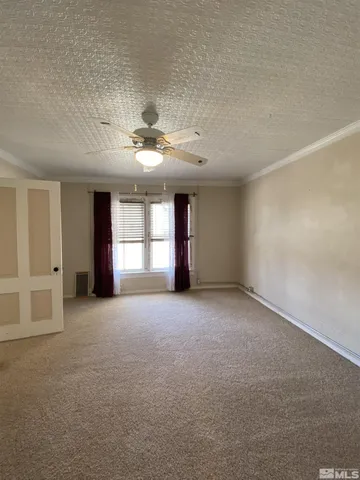 a view of a livingroom with a ceiling fan and window