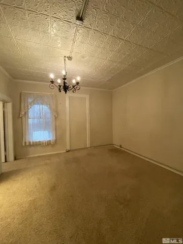 a view of a big room with chandelier fan and windows