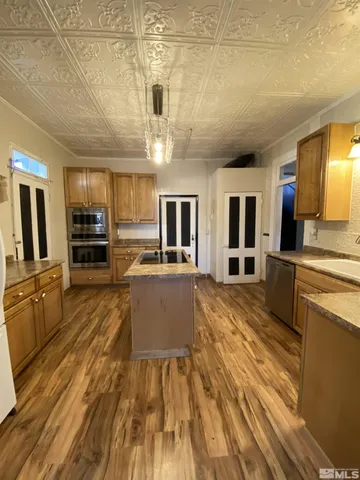 a kitchen with stainless steel appliances granite countertop a sink a stove and a refrigerator