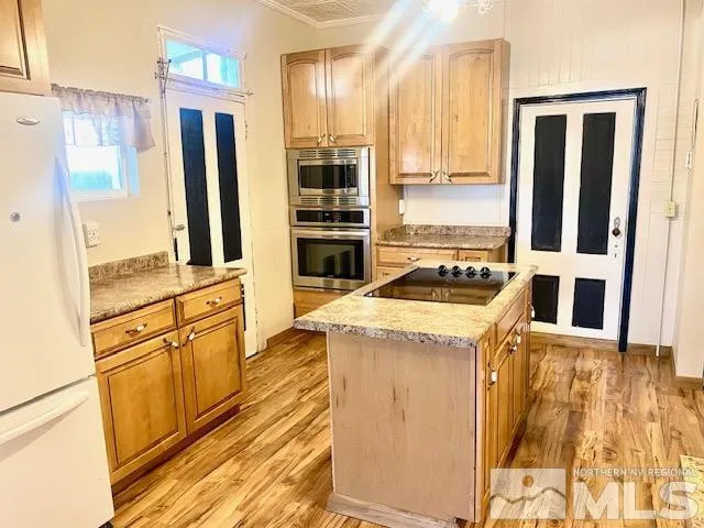 a kitchen with granite countertop a refrigerator and a stove top oven