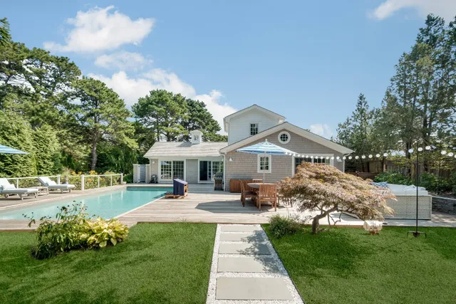 a front view of a house with a garden and trees