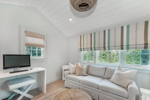 a living room with furniture a flat screen tv and a window