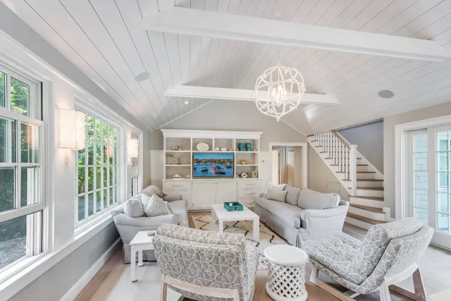 a living room with furniture a chandelier and a large window