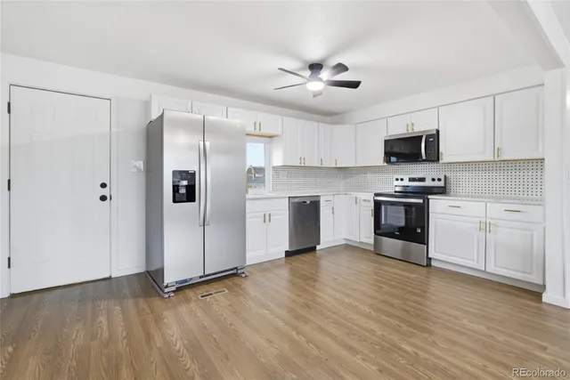 a view of kitchen with wooden floor and electronic appliances