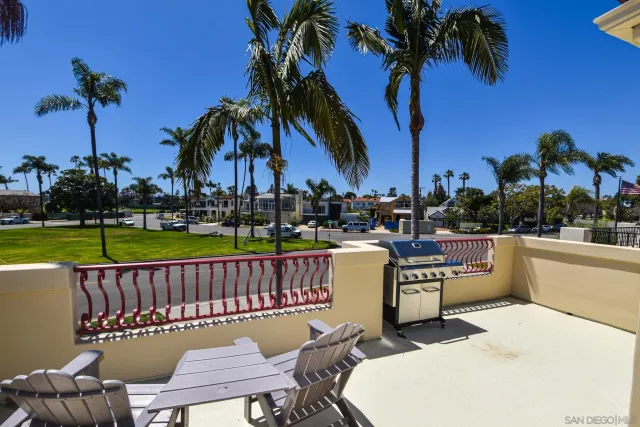 a view of a swimming pool with lawn chairs potted plants and palm trees