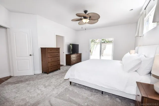 a spacious bedroom with a bed and a chandelier