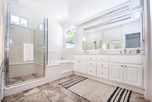 a bathroom with a double vanity sink a mirror and a shower