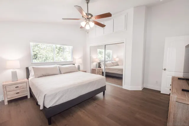 a bedroom with a large bed and a chandelier