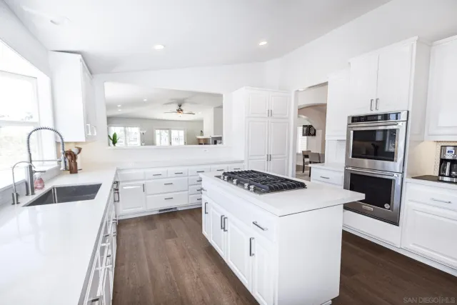 a kitchen with appliances a sink and cabinets