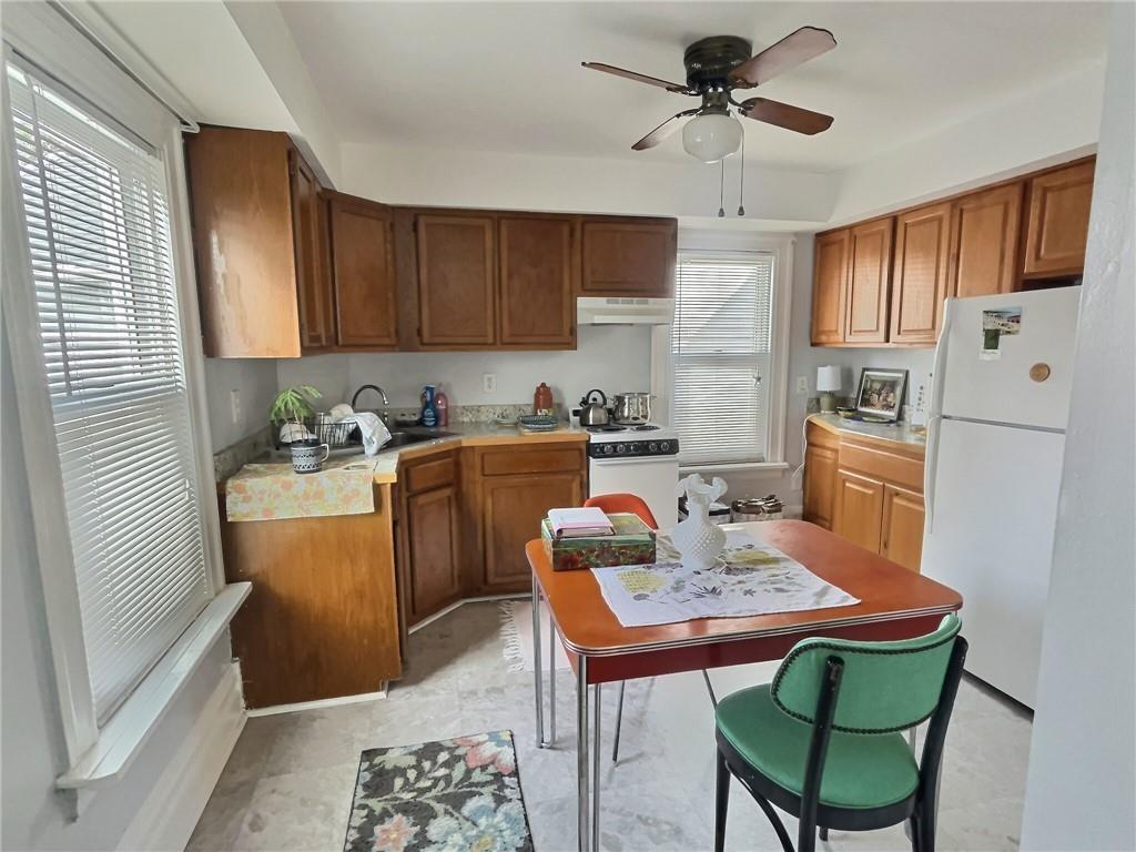 724 Washington Street, Unit 2 Sewickley, PA 15143 - Photo 5 of 18 a kitchen with stainless steel appliances granite countertop a refrigerator a sink a stove a dining table and chairs with wooden floor