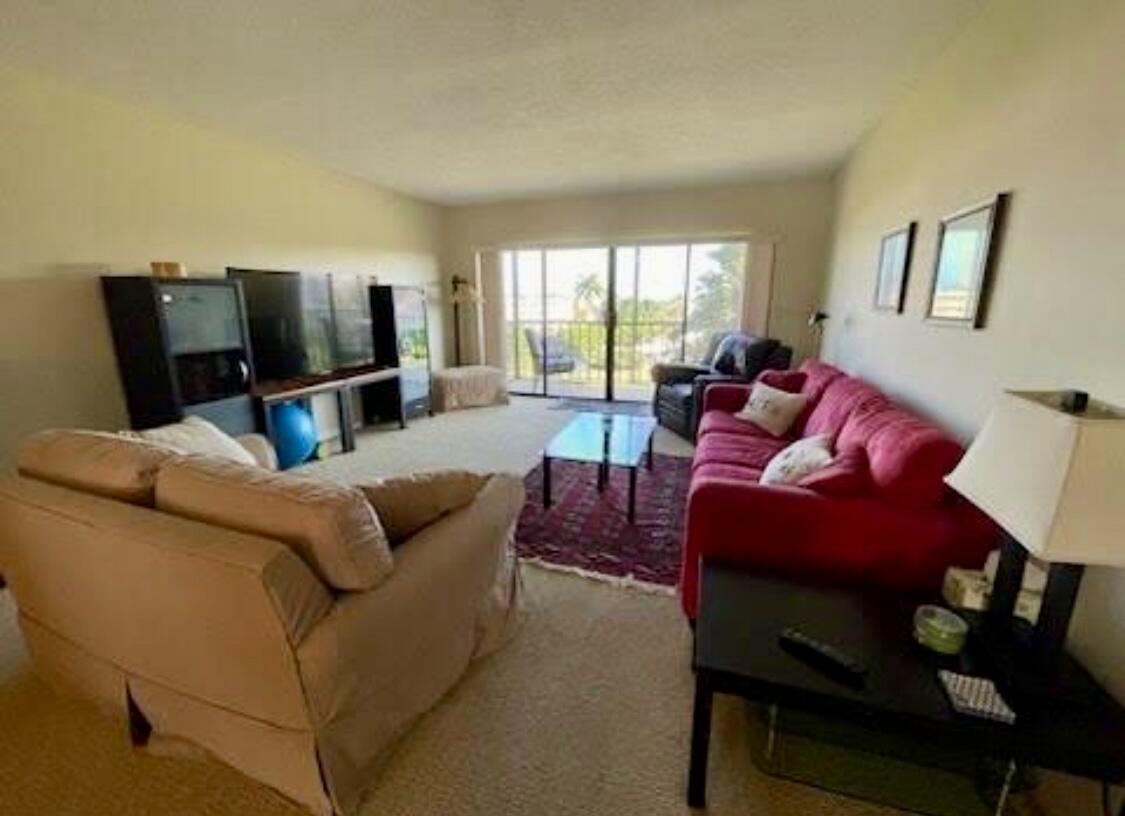 300 North Hwy A1A, Unit 405M Jupiter, FL 33477 - Photo 3 of 11 a living room with furniture and a flat screen tv