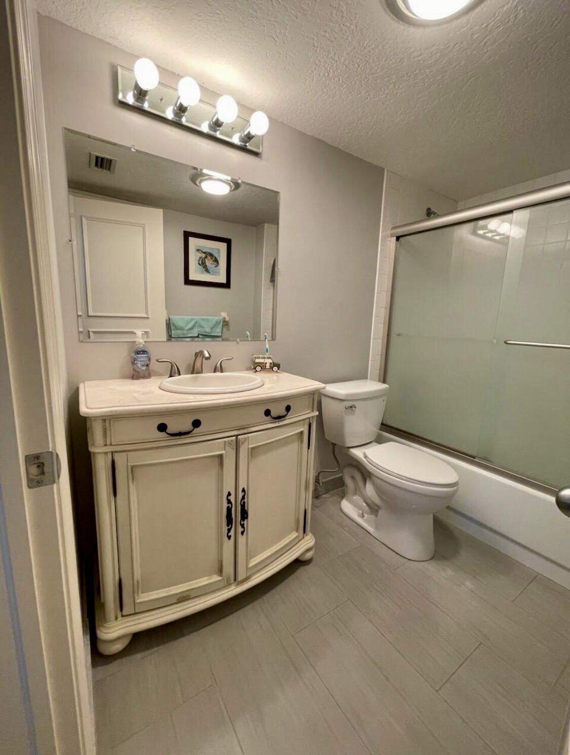 300 North Hwy A1A, Unit 405M Jupiter, FL 33477 - Photo 7 of 11 a bathroom with a sink toilet and mirror